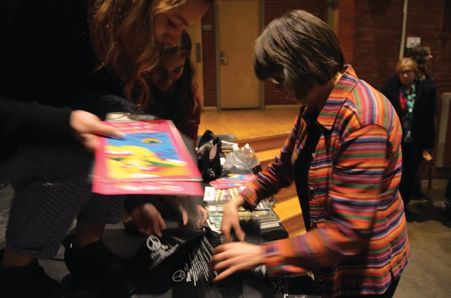 Mary Beth Tinker hands out coloring book and black arm bands to students at North Des Moines High School this past Thursday, Dec. 16 to celebrate the 50th anniversary of her middle school suspension that sparked the Supreme Court case Tinker v. Des Moines.