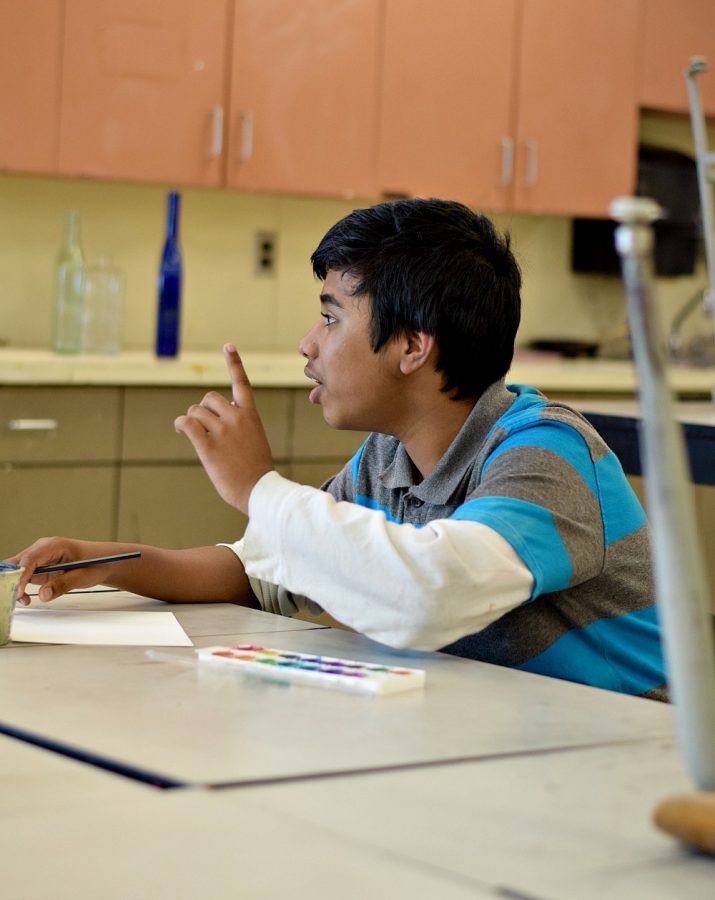 Tanim Haque '20 talks with his friends, while sketching. 