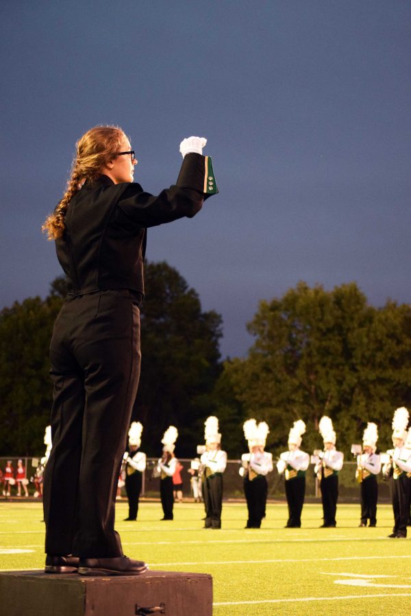 Lauren Ernst 18 conducts the marching band before the first quarter of the game.