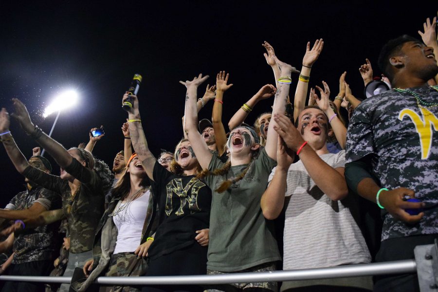 The West High student section cheers on the marching band.