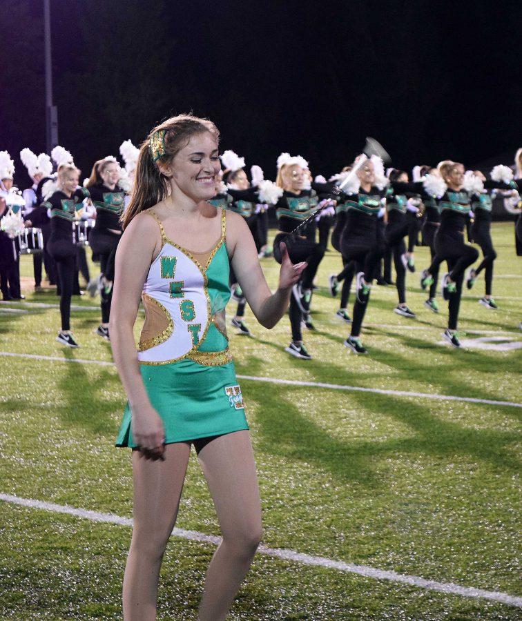 Arielle Comellas 18 twirls her baton during the halftime show.