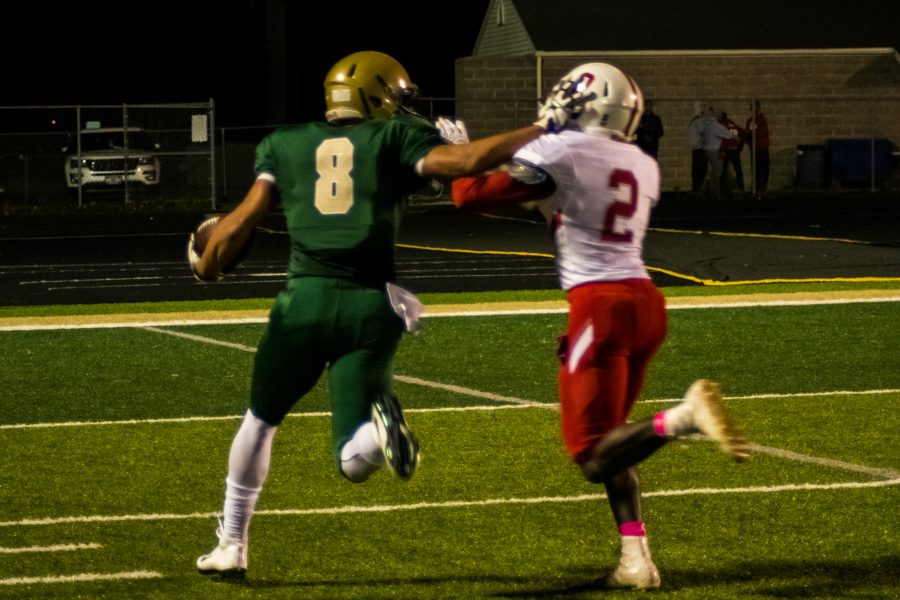 Oliver Martin 17 pushes off a defender as a runs towards the end zone