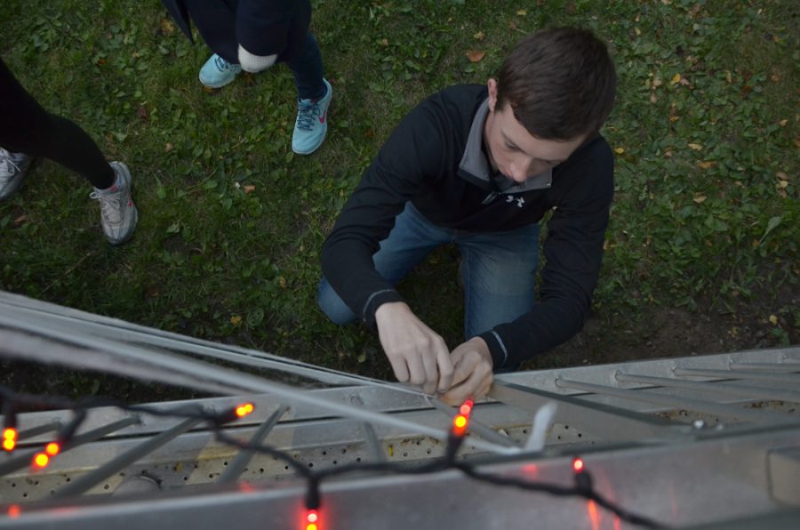 Pinning up spider webs, T.J. Hillberry '18 helps decorate before the show.