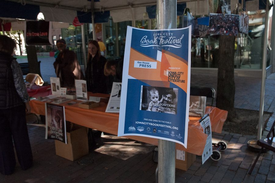 An Iowa City Book Festival poster hanging on an author
 booth. 