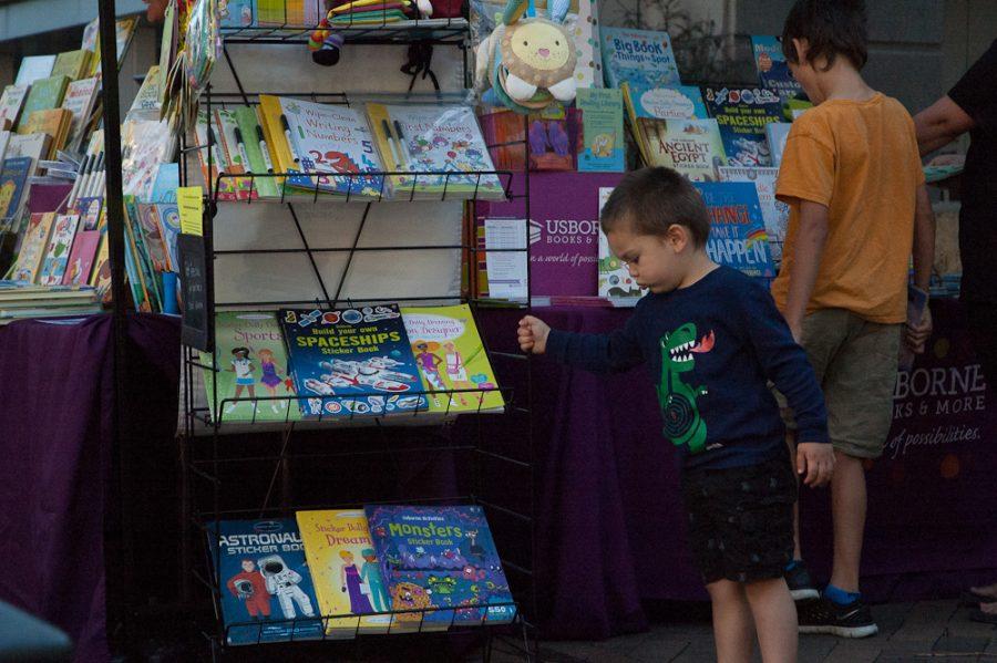 A young boy looks at a children's book booth.