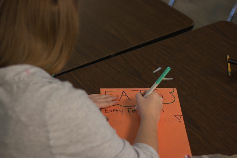 EATS club member makes posters to advertise for the club.