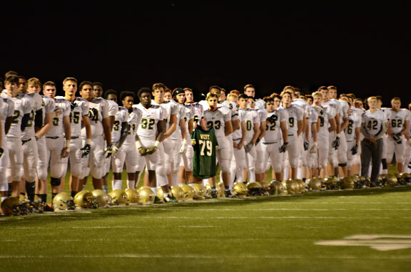The West High football team held Tony Beminos old high school jersey during a moment of silence and the National Anthem during Nov. 4s game.