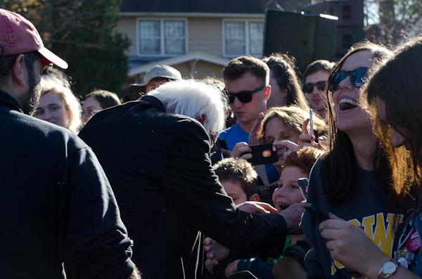 At the start of a newly formed human tunnel, Sen. Sanders greets a young boy after his speech.