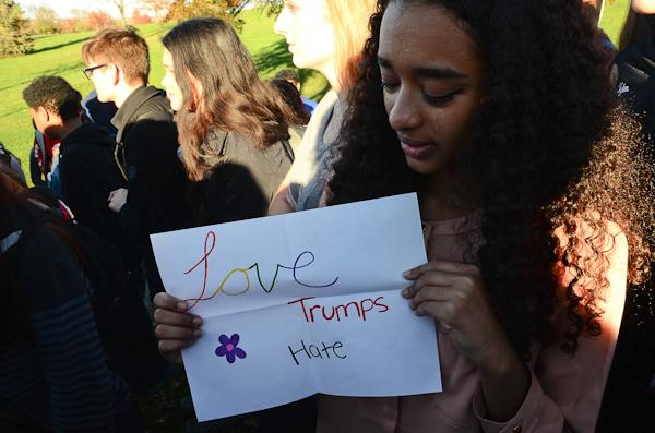 Unfolding a poster, Xena Makky '18 displays "Love Trumps Hate."