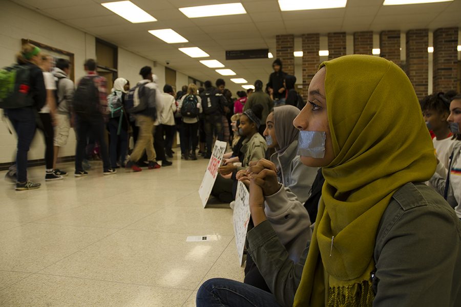 Protestors remain silent while students and faculty members walk by after school is dismissed. 