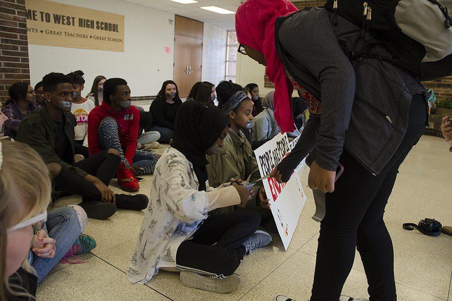 Ala Mohamed '17 cuts tape for a fellow peer joining the sit-in. 