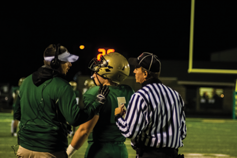 A referee talks to Breyton McDole `17 and a football coach during the home football game against Ottumwa on Oct. 21.