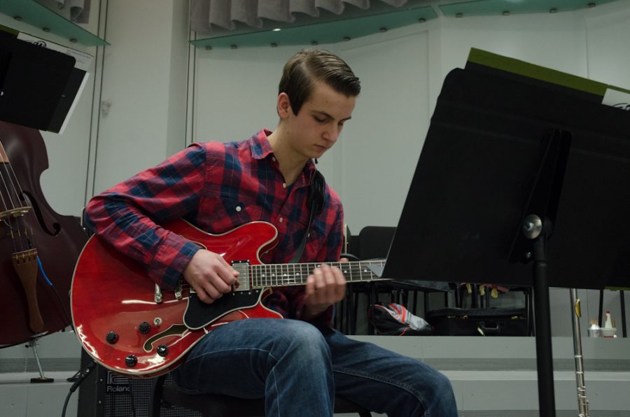 Daniel Burgess '18 performs in the SEIBA Jazz Band with his cherry red guitar. 