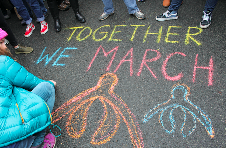 while there were many people at the march people make a hole in order for the woman to write Together We March on the street  