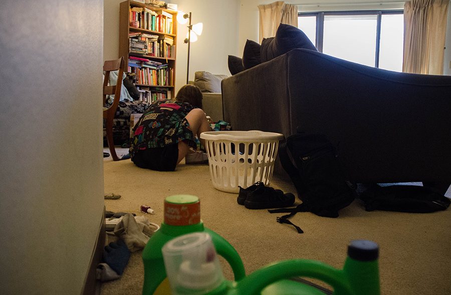 Shaver puts on her shoes to get ready to head outside. She keeps many of her important possessions behind the couch, such as an Arctic  Monkeys vinyl and a stained glass project she completed at school. 