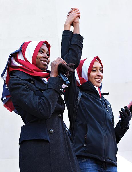 Ala Mohamed 17 and Raneem Hamad 17 acknowledge the crowd at an Anti-Ban rally in downtown Iowa City after reciting a poem written by Mohamed. Aside from poetry, the rally also featured speeches and music as over 1,500 people gathered in solidarity. 