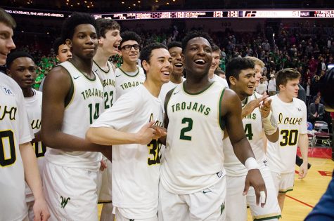 After winning 57-51 in the 4a state quarterfinals against Newton High School, the boys basketball team celebrates their progression through the state tournament at Wells Fargo Arena, Wednesday Mar. 8. The Trojans later advanced to play Kennedy High School in the state semifinals, and won 61-37. 