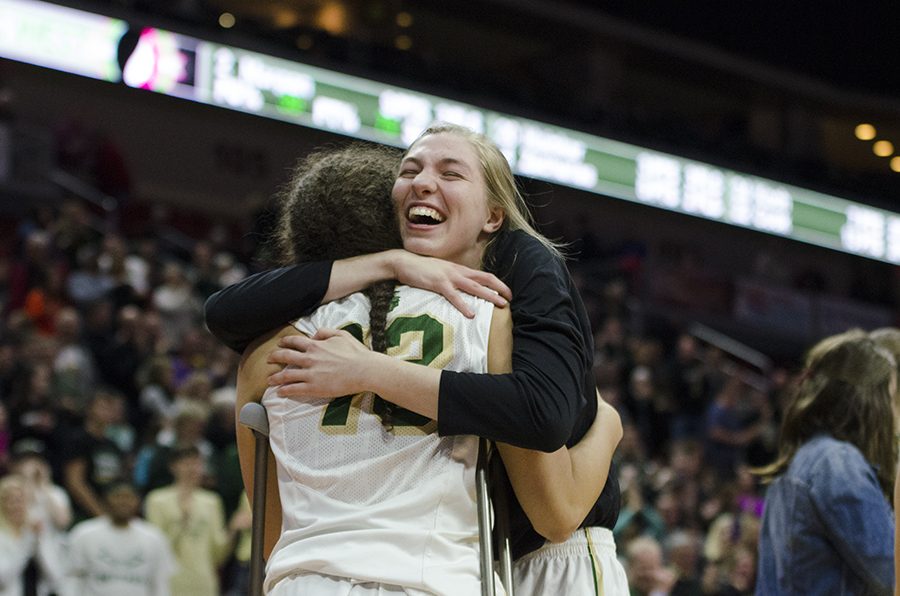Senior Ali Tauchen hugs Rachel Saunders 18 after the girls won against Waukee in the girls state quarter finals 40-38. Saunders, pictured in crutches, suffered from a knee injury in the first quarter where she also scored a three pointer. 