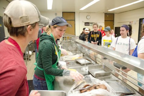 Volunteer Julie Peters prepares and serves a plate of pancakes, eggs and sausages as a part of the annual Booster Club Pancake Day for athletic funding in Iowa City Schools on Sat. April 8, 2017. 