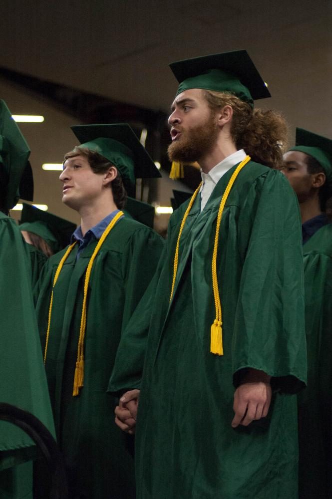 Hand in hand, Ethan Upchurch 17 and Andre Magalhaes 17 sing The Road Home by Stephen Paulus as a part of the Senior Music Ensemble at the forty-ninth annual commencement ceremony for West High at Carver-Hawkeye Arena on May 27. 