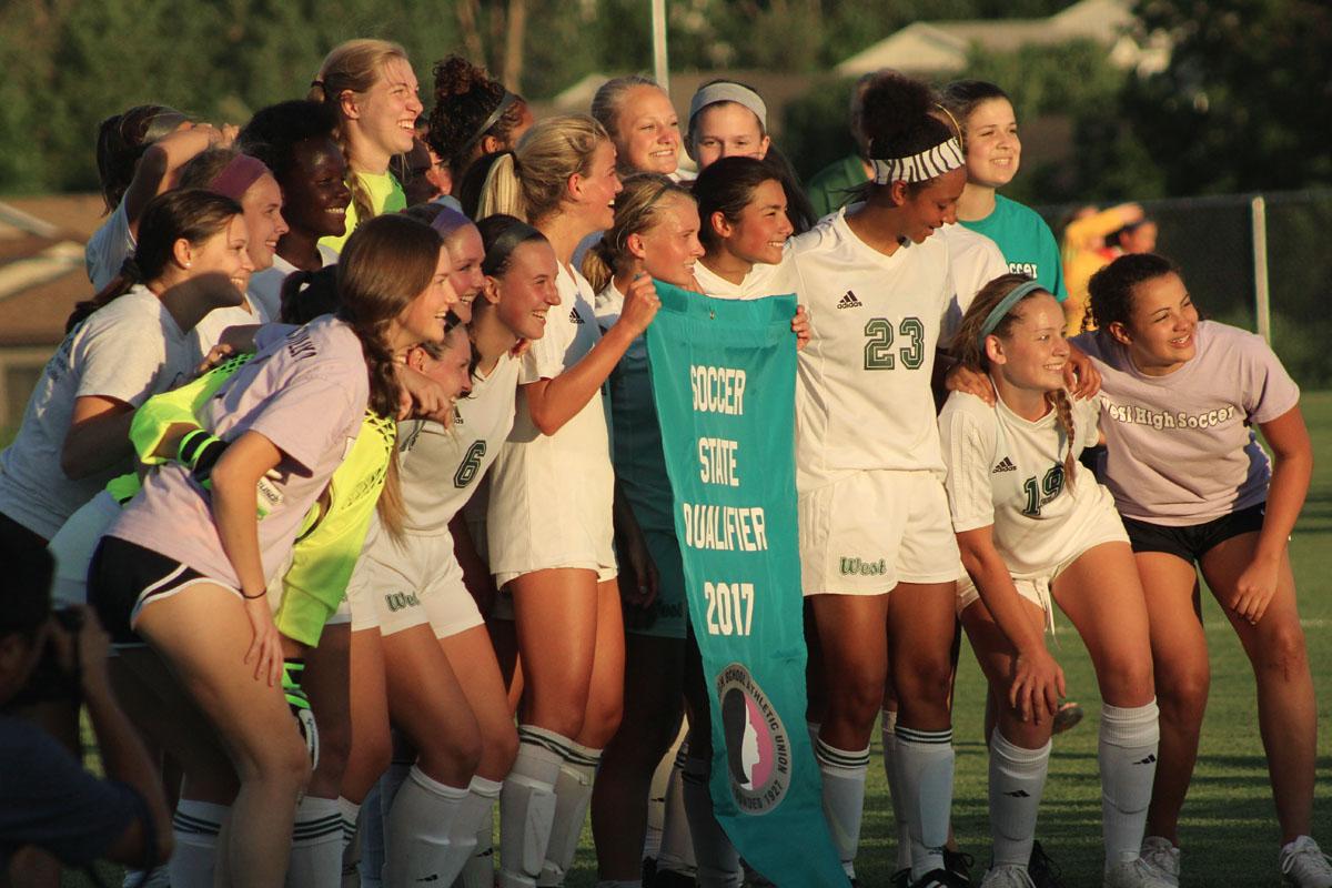 The team celebrates with their state qualifying banner after the game.