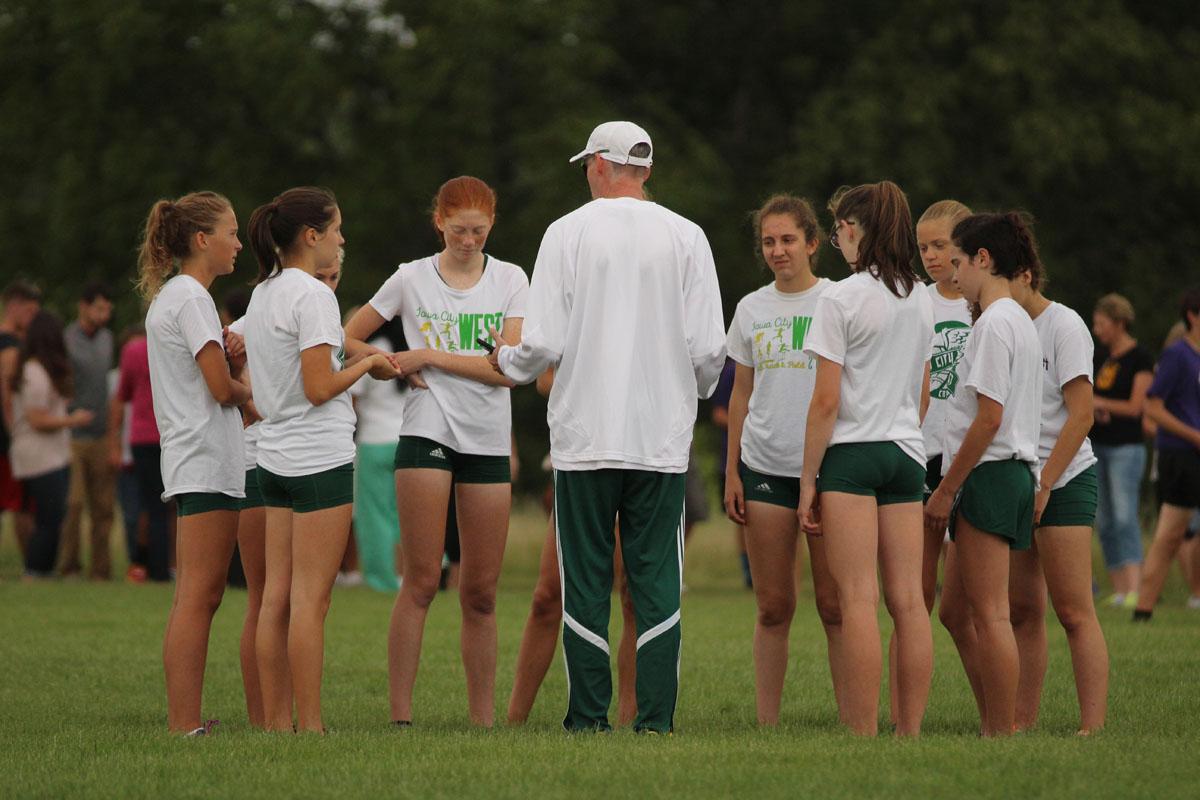 The varsity team gathers around Coach Mike Parker for a pep talk before the race on Thursday, Aug. 24.