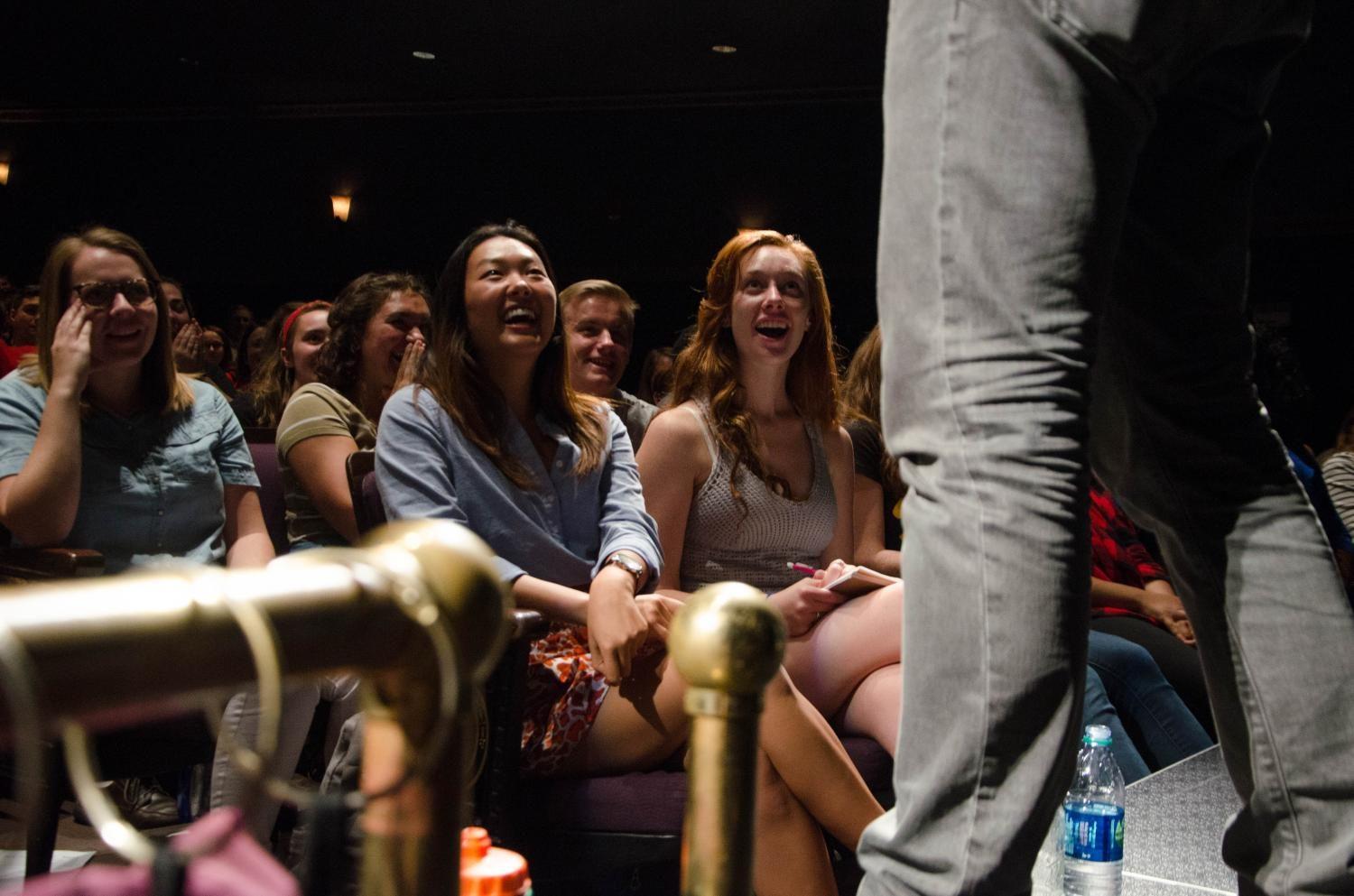 University of Iowa students laugh in wonder as magician Nate Staniforth drinks the ashes of a dollar bill as a part of a trick on Sept. 11 at the Englert Theatre. 
