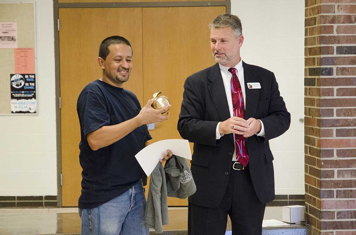 Superintendent Stephen Murley awards custodian Daniel Carlos with the Shine Award on Sept. 13 in the main commons. 