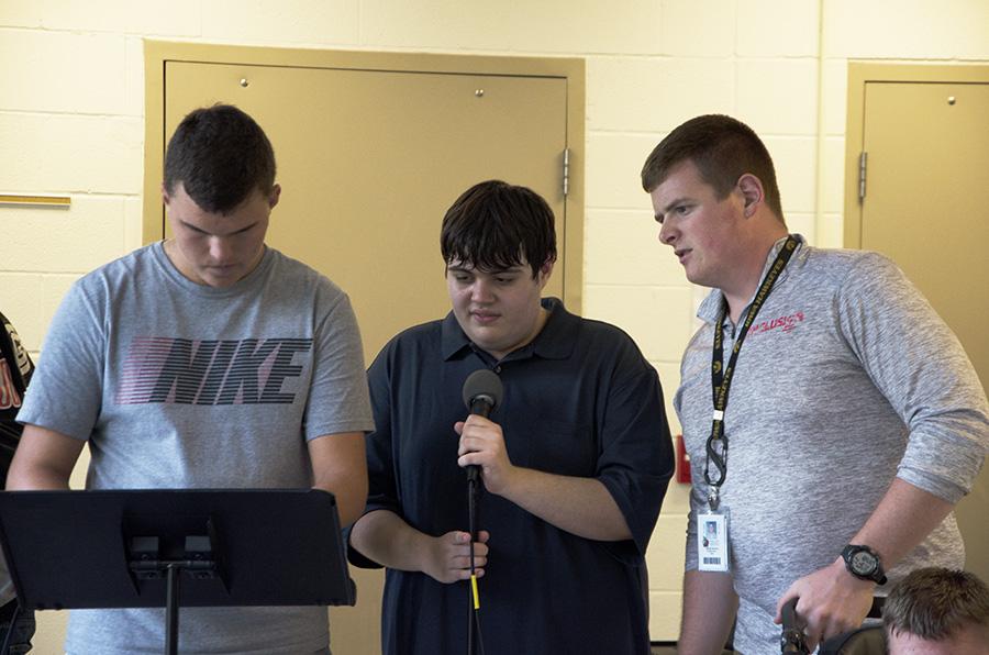 Brad Dileo 18 and Jacob Sexton helps Chase Lonngren 20 pick out a song to sing.