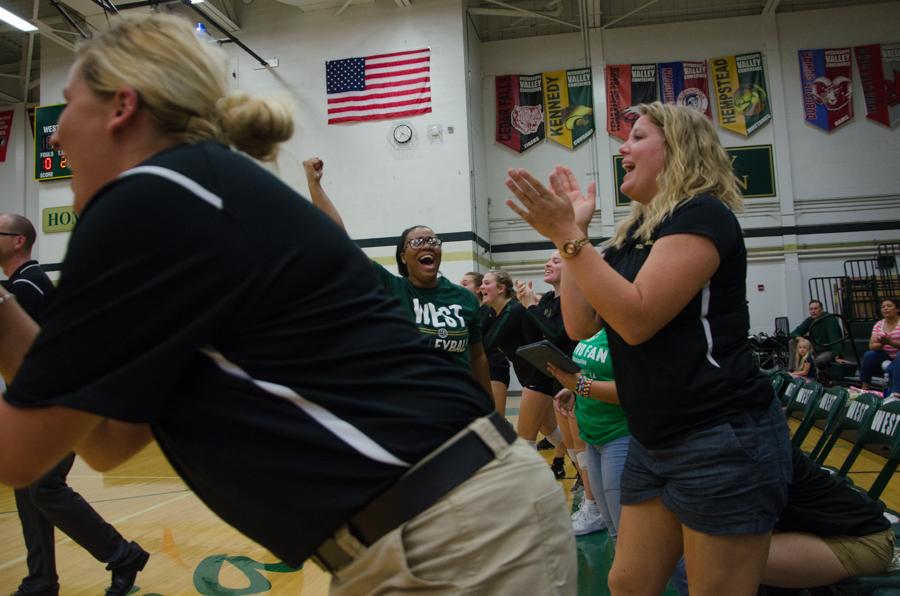 Assistant coach Whitney Lang cheers after the varsity volleyball team scored a point in the game against Jefferson on Sept. 26.