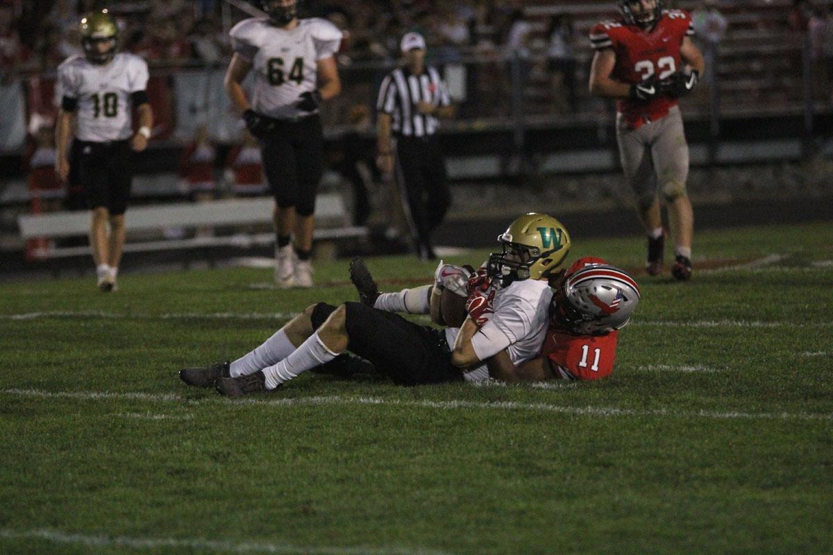 Austin Geasland '18 holds onto the ball as City's Marquel Poole '18 tackles him to the ground on Friday, Sep. 15. 