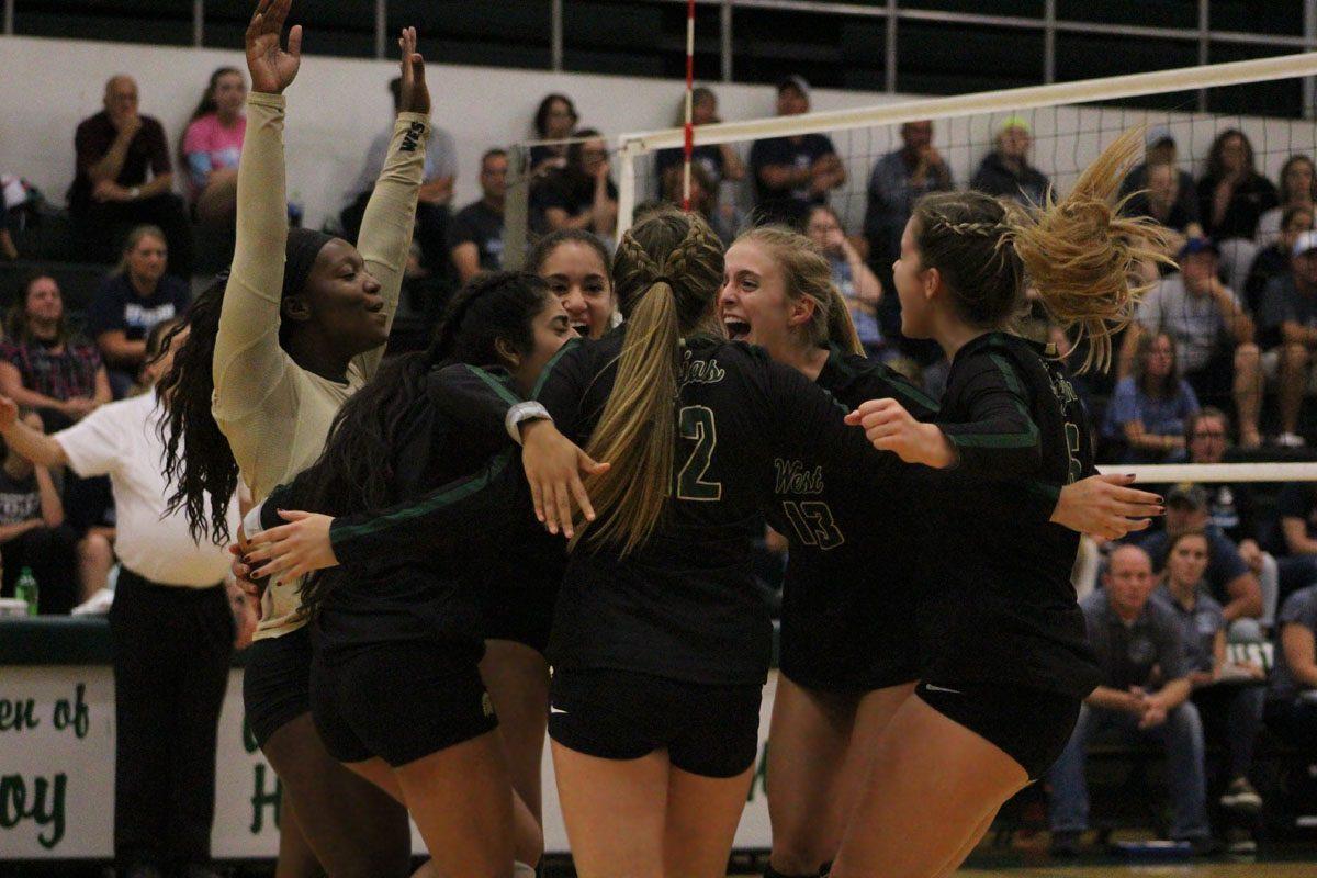 The team celebrates after they gain a lead on Jefferson in the first set on Tuesday, Sept. 26.