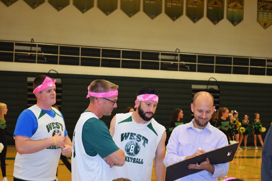 Teachers (left to right) Jacob Sexton, Tyson Smith, and Nathan Frese consult Alexander Lalagos for their strategy.