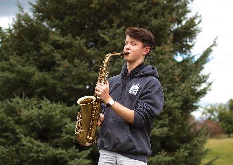 Ethan Buck 21 plays his alto saxophone in the West High courtyard.