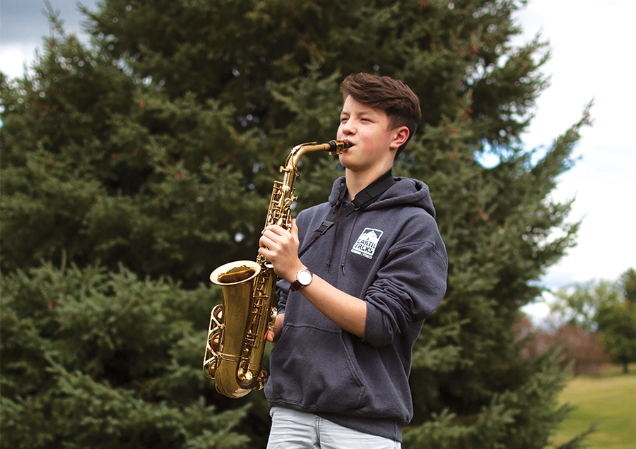 Ethan Buck 21 plays his alto saxophone in the West High courtyard.