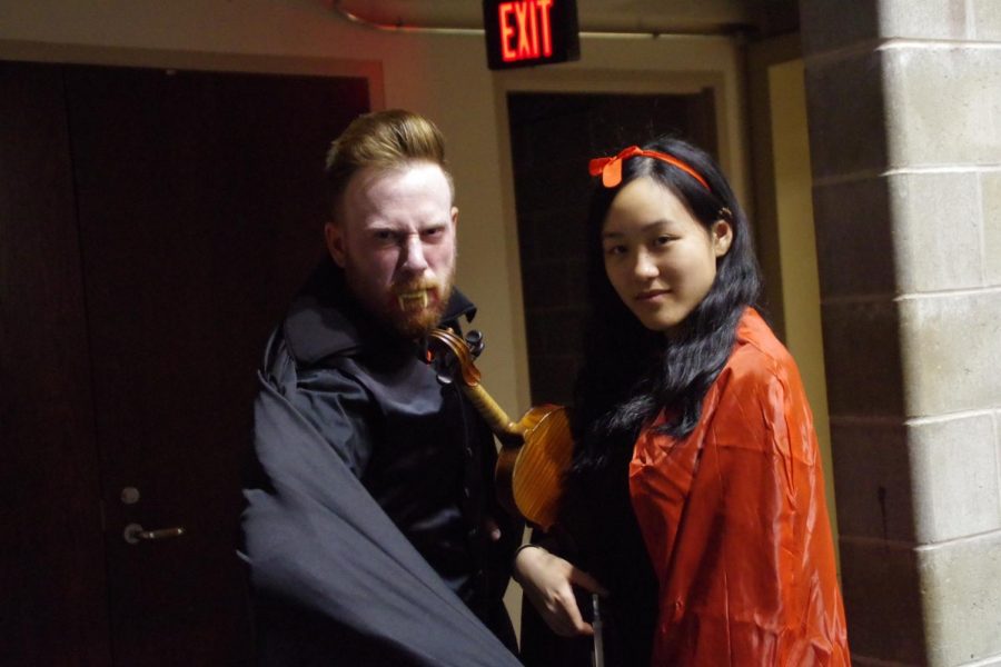 Dressed as a vampire, West High orchestra conductor Jonathan Welch poses for a photo with symphony concert master Annie Chen 18 on Oct. 26.