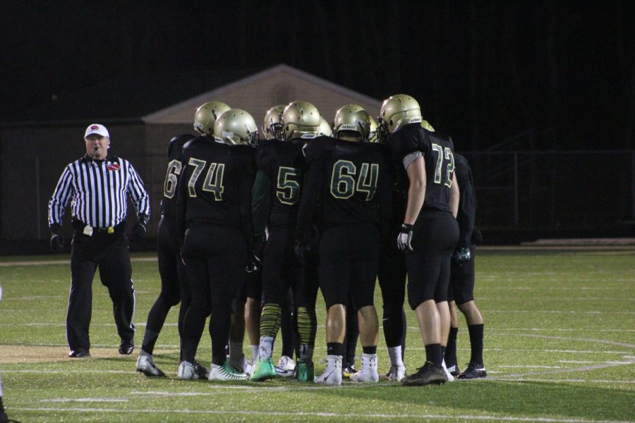 The offensive team huddles around quarterback Evan Flitz '18 as he directs them on Friday, Oct. 27.