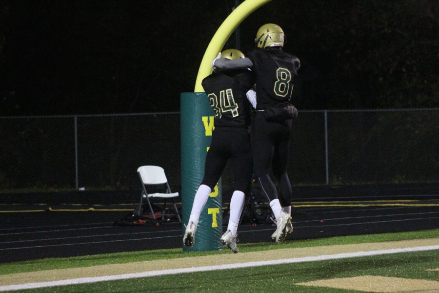 Austin Geasland '18 jumps up to celebrate with 	Peter Breitbach '19 after Breitbach scored a touchdown on Friday, Oct. 27.