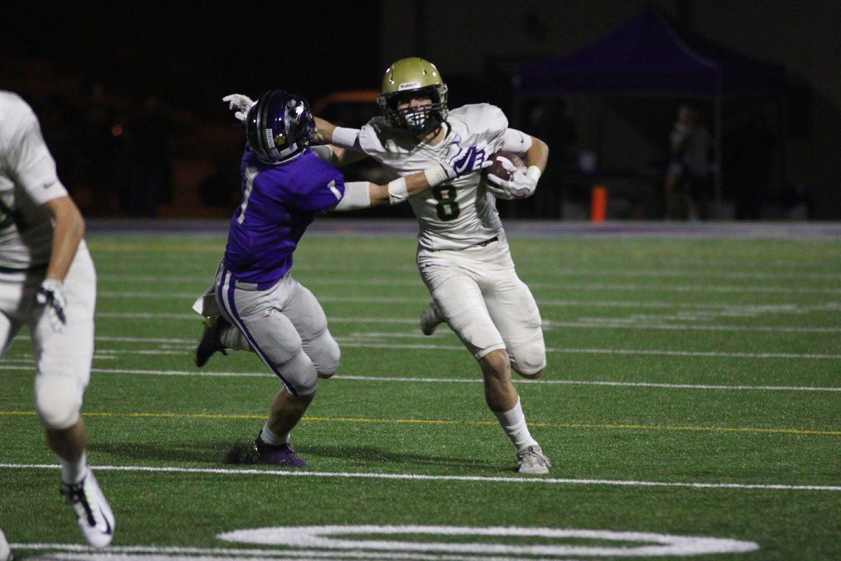 Austin Geasland '18 stiff arms Burlington's Mason Leinbach '18 as he moves up the field on Friday, Sept. 29.