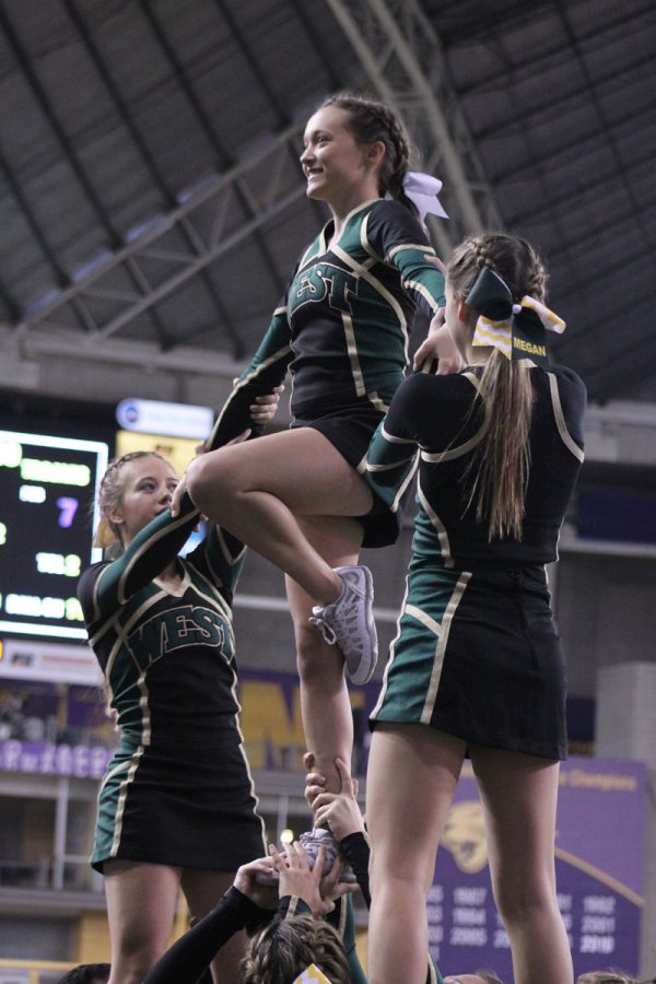 Ella Gibson '18 and Megan Herring '18 help keep Allie Hambright '18 steady during a stunt on Friday, Nov. 17.