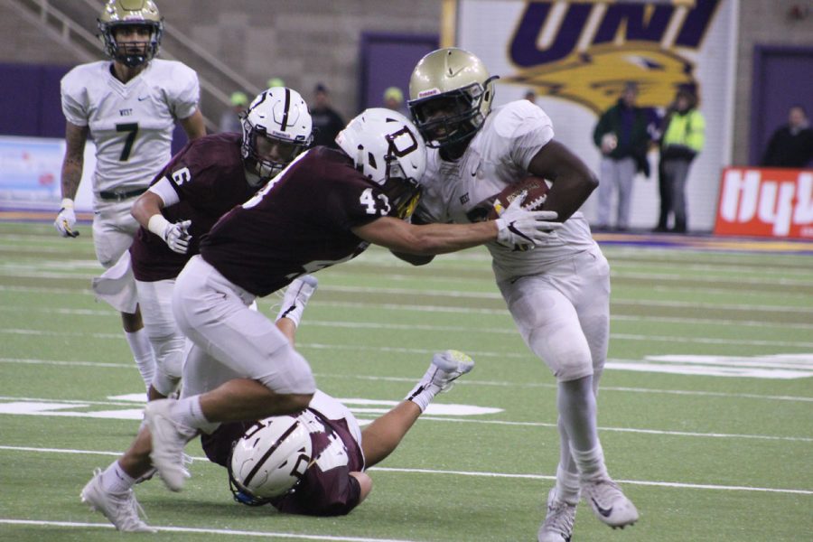 Trumell Roberts '18 runs the ball for West as Dowling's Jack Bertram '18 tries to tackle him on Friday, Nov. 17.