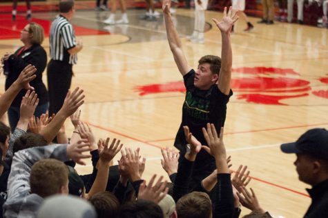 Austin Geasland 18 leads the student section in a cheer during the varsity basketball games against City on Dec. 12.