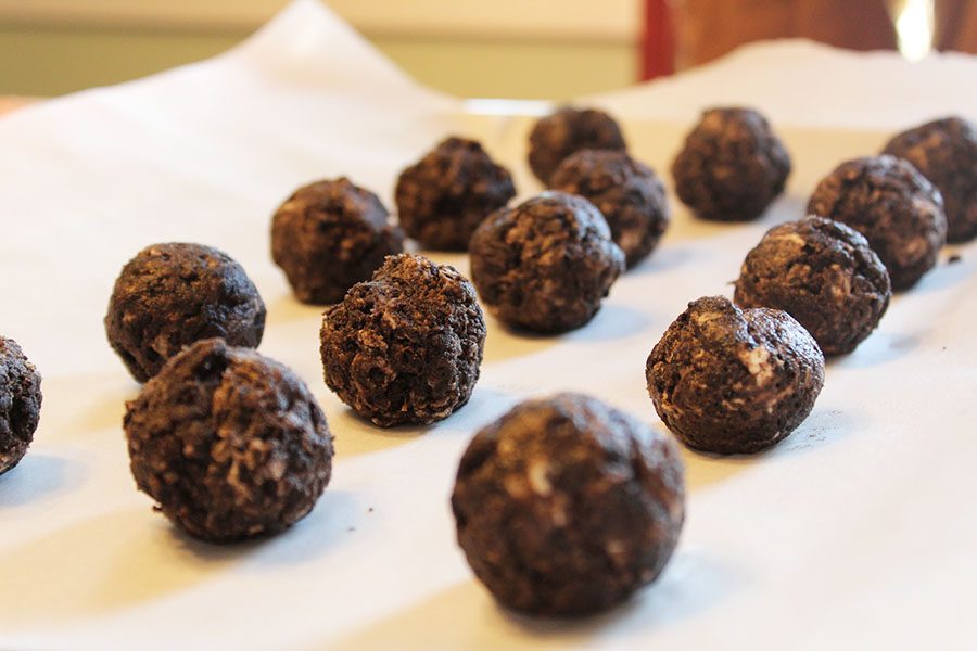 The cake balls have been formed into small balls using our hands, then placed onto a cookie sheet where they cooled in the refrigerator for a while.