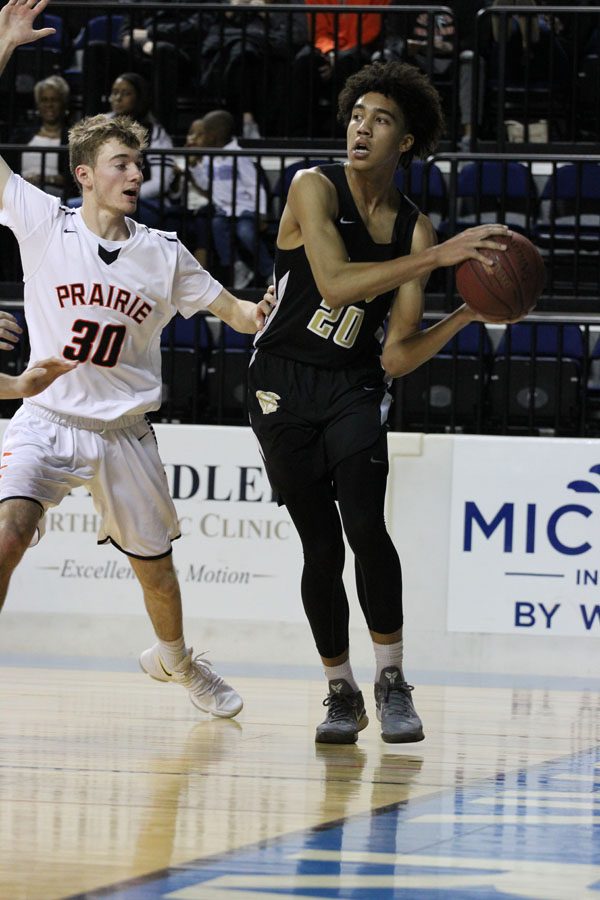 Dadrian Hoambrecker '18 looks for a fellow Trojan to pass to while Prairie's Harrison Cook '19 defends him on Saturday, Jan. 20.