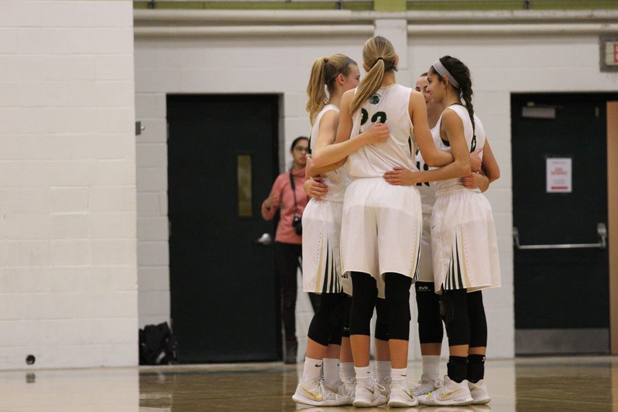Lauren Zacharias 19, Emma Koch 19, Logan Cook 18, Cailyn Morgan 19 and Rachael Saunders 18 huddle together at the beginning of the game on Tuesday, Jan. 23.