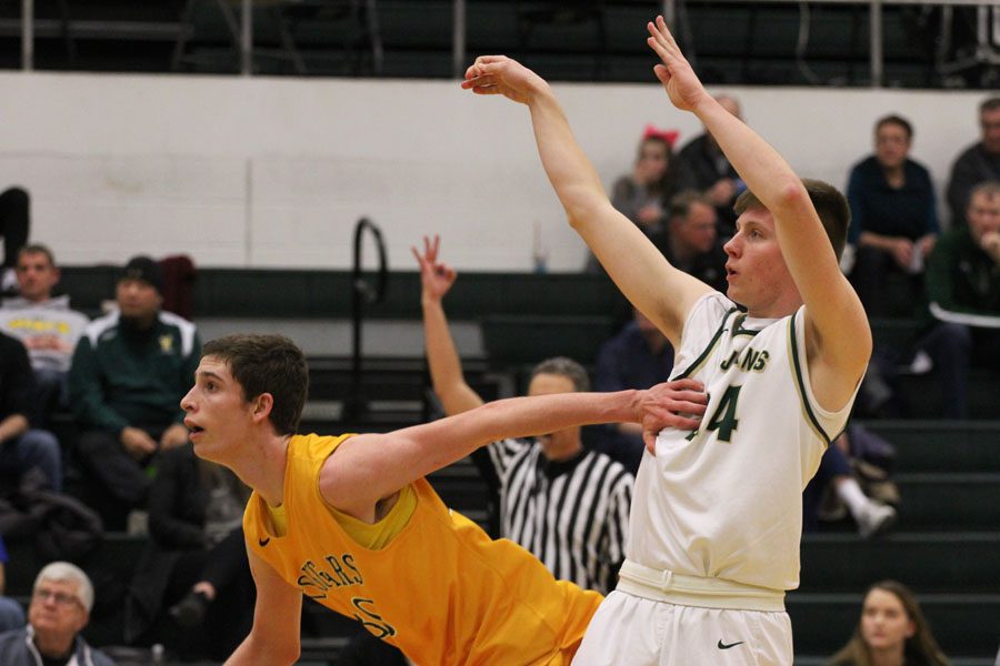 Jayson Barnes '18 shoots the ball as Kennedy's Jack Wetzel '20 holds him back on Tuesday, Jan. 30.