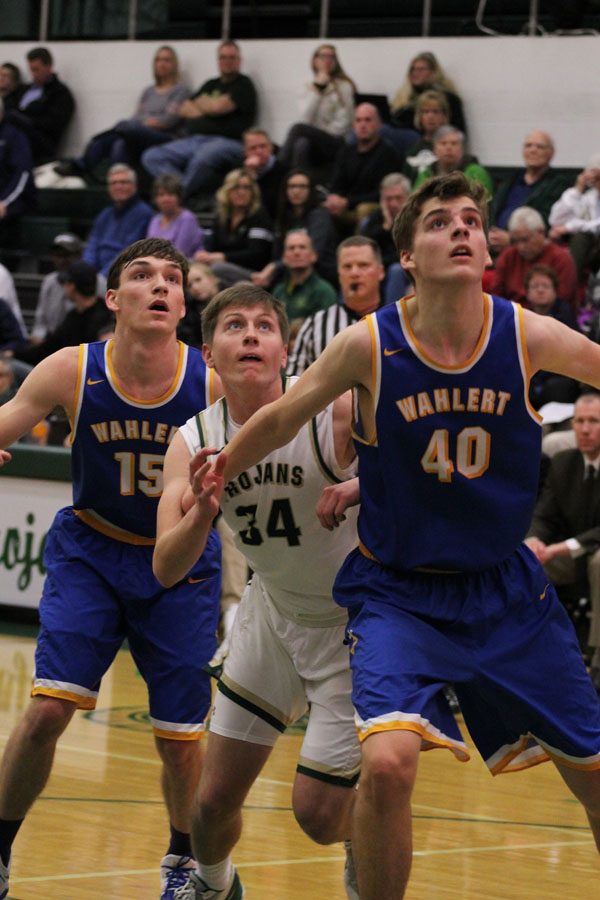 Jayson Barnes '18 tries to rebound the ball as Wahlert's Jack Jaeger '18 and Sam Gruhl '18 box him out on Friday, Jan. 5.