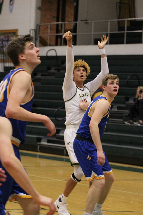 Seybian Sims '18 shoots a jump shot as he gets guarded by a player from Wahlert on Friday, Jan. 5.