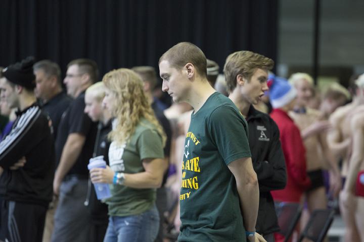 Coach Byron Butler watches his swimmers warmup before the meet on Sat., Feb. 10.