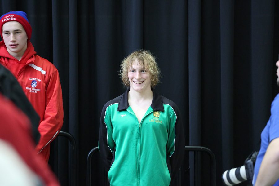 Lane Griffis '18 smiles on the podium after he placed 8th overall in the 500 free race with a time of 4:46.05 on Sat., Feb. 10.